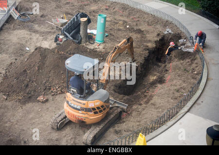 Lavoratori scavare una trincea in un complesso di appartamenti situato nel quartiere di Chelsea di New York per lavorare su un miglioramento del drenaggio progetto, visto il giovedì, 30 aprile 2015. (© Richard B. Levine) Foto Stock