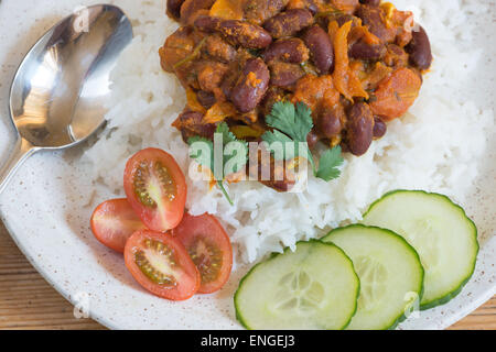 Fagiolo curry di riso basmati con insalata di cetrioli e piccole tagliate i pomodori a piombo Foto Stock