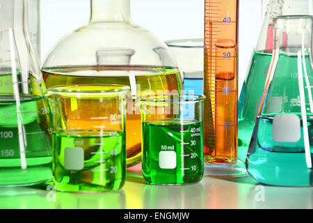 Vista ravvicinata di vari articoli di vetreria di laboratorio sulla tabella riflettente Foto Stock