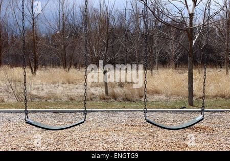 Immagine di due lonely oscillare in un parco giochi canadese Foto Stock