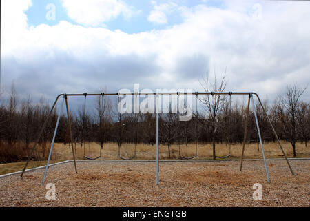 Fotografia loners inverno cottura oscilla in un parco giochi in Canada Foto Stock