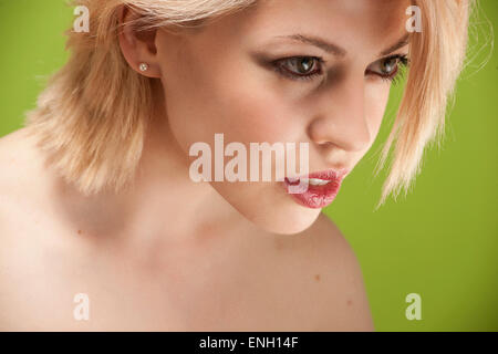 Sfondo verde bellezza headshot di giovane donna bionda Foto Stock