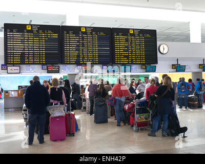 Aeroporto Spagna schermate informative e code di passeggeri e bagagli delle compagnie aeree aspettano sul atrio dell'aeroporto per effettuare il check-in al volo Foto Stock