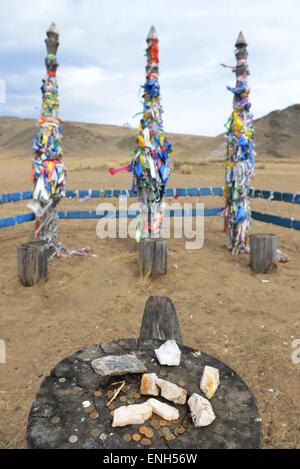 Pali in legno con nastri colorati (importanti in sciamanesimo) in un piccolo Shamanistic area cerimoniale nella regione Baikal. Foto Stock