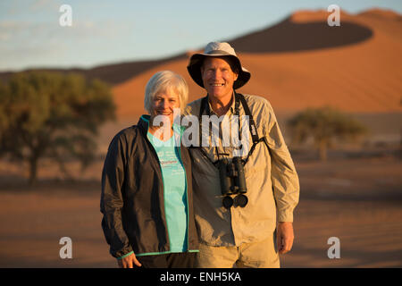 Africa, Namibia. Deserto del Namib. Sossusvlei, Naukluft Park. Coppia felice su dune di sunrise. Modello rilasciato. Foto Stock