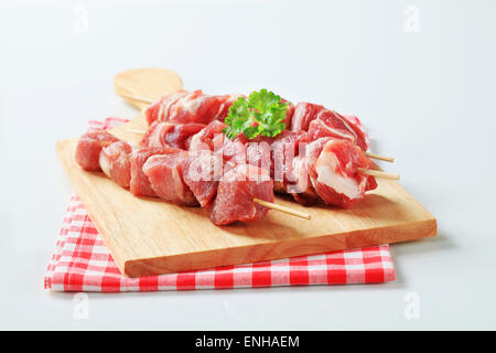 Carne di maiale cruda spiedini sul bordo di taglio Foto Stock