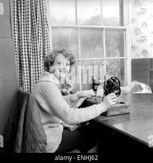 Donna che utilizza la macchina per cucire. Circa 1964 un1137B-002 Foto Stock
