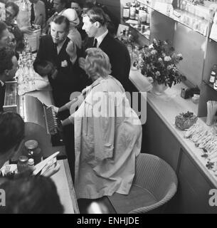 Actrice americano Marilyn Monroe e Sir Laurence Olivier cercano rifugio dai fotografi in attesa dietro un contatore all'aeroporto di Heathrow. Monroe aveva appena volato a Londra con il marito, drammaturgo Arthur Miller e Vivien Leigh. Marilyn è qui per fil Foto Stock