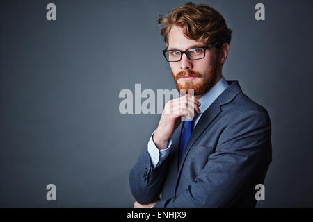 Fiducioso imprenditore elegante da indossare tuta e occhiali Foto Stock