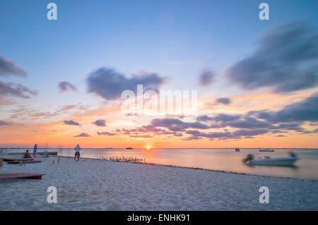 Isla Mujeres, Messico - 24 Aprile 2014: tramonto lunga esposizione con spiaggia, barche e turisti sulla famosa Playa del Norte in spiaggia è Foto Stock