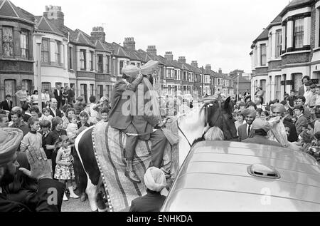 La religione sikh groom rende partenza tradizionale, su di un cavallo, per le sue nozze, raffigurato nella strada Conington, Lewisham, a sud di Londra, agosto 1965. Foto Stock