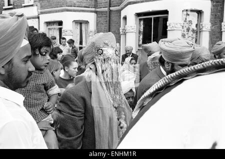 La religione sikh groom rende partenza tradizionale, su di un cavallo, per le sue nozze, raffigurato nella strada Conington, Lewisham, a sud di Londra, agosto 1965. Foto Stock