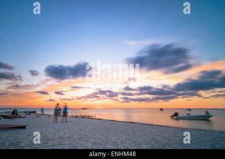 Isla Mujeres, Messico - 24 Aprile 2014: tramonto lunga esposizione con spiaggia, barche e turisti sulla famosa Playa del Norte in spiaggia è Foto Stock