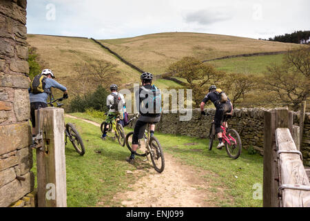 Quattro mountain bikers avente un periodo di riposo prima di proseguire lungo il sentiero nella Derwent Valley nel Peak District Foto Stock