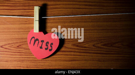 Cuore rosso parola miss su legno vintage stile sfondo Foto Stock