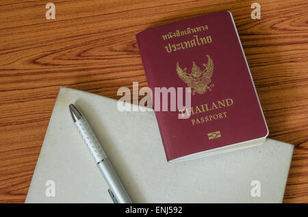 Passaporto thai con i notebook su legno sfondo tabella Foto Stock