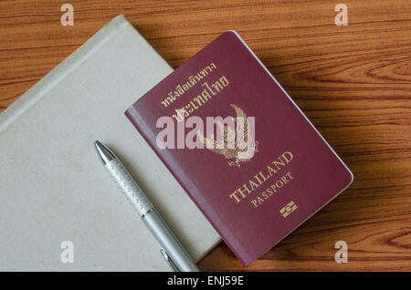 Passaporto thai con i notebook su legno sfondo tabella Foto Stock