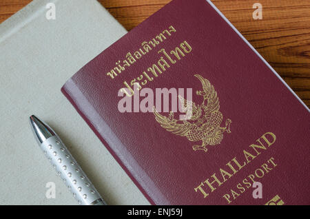 Passaporto thai con i notebook su legno sfondo tabella Foto Stock