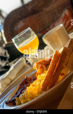 Tipica colazione americana con uova strapazzate, bacon, fingerling patate, toast, succo d'arancia e caffè. Cheeca Lodge & Spa, Florida, Stati Uniti d'America Foto Stock