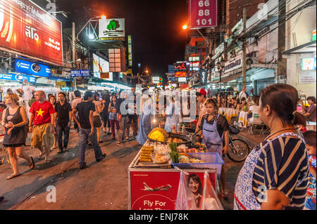 Commercianti di strada, la gente del posto e i turisti si mescolano lungo la Khao San Road di notte. Bangkok. Thailandia. Foto Stock