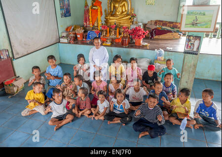 Un gruppo di bambini con la monaca buddista Pimjai Maneerat nell'orfanotrofio a Sangkhlaburi. La provincia di Kanchanaburi. Della Thailandia Foto Stock