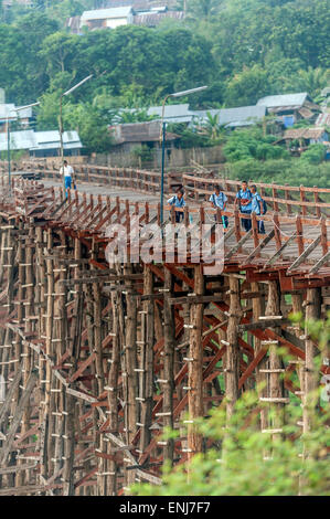 Gli scolari locali attraversando il traballante ponte di legno (Saphan Mon) Sangkhlaburi. La Provincia di Kanchanaburi. Thailandia. Foto Stock