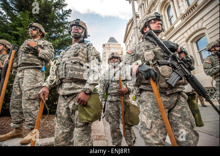 Nazionale di unità di guardia a guardare oltre le manifestazioni di protesta in corso a Baltimora vicino municipio dopo la cop relativi alla morte di Freddie grigio è scoppiata in violenti scontri, girato a dimostrazioni pacifiche Foto Stock