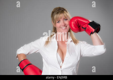 Boxer femmina indossa red 10oz guantoni da pugilato. Prendendo un punzone per il viso. Foto Stock