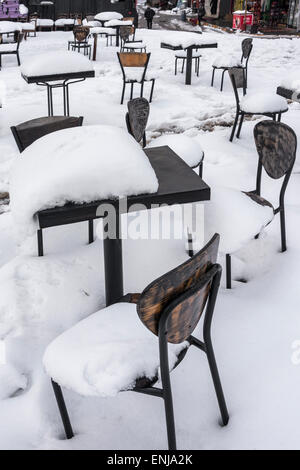 La neve e il ghiaccio che ricopre il cafe e i tavoli e le sedie in Karakoy, Istanbul, Turchia. Foto Stock