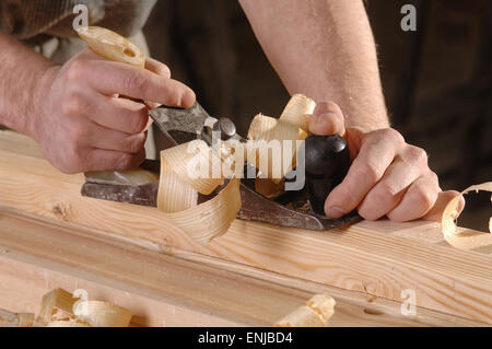 L'uomo le mani con i falegnami di piano su sfondo di legno Foto Stock