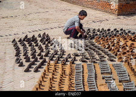 Bhaktapur, Nepal - 20 marzo 2015: giovane immissione potteries a secco sulla piazza di ceramiche. Foto Stock