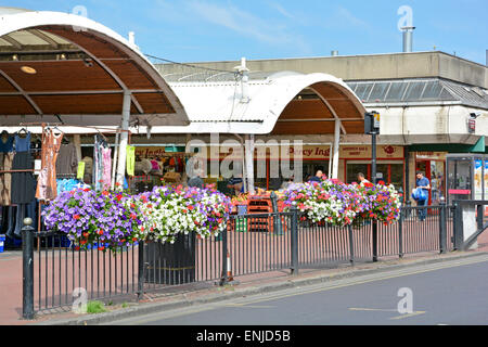 Fiori d'estate sul marciapiede di ringhiere fuori mercato Queens in verde strada adiacente a Upton Park Station Newham Est Londra Inghilterra REGNO UNITO Foto Stock