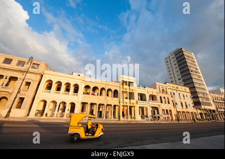 Moto rickshaw unità nella parte anteriore dell'architettura coloniale di rivestimento del Malecon strada lungomare nel centro di Avana, Cuba Foto Stock