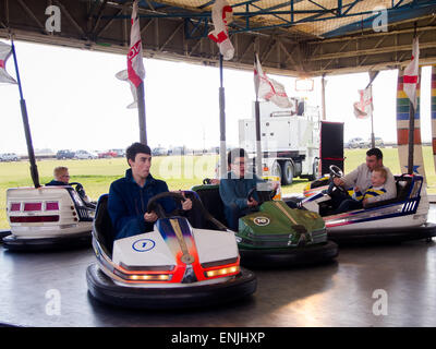 Persone guida dodgem auto in un viaggio in fiera Foto Stock