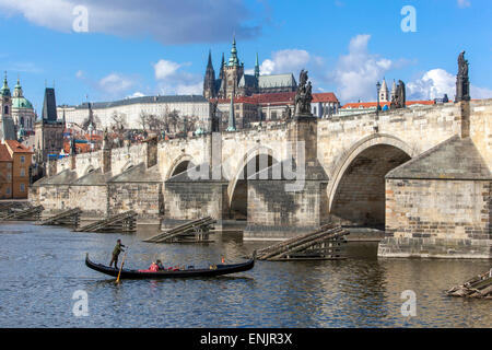 Panorama del Ponte Carlo e del Castello di Praga con vista sul fiume Moldava Gondola veneziana, gondolieri Repubblica Ceca edifici famosi in tutto il mondo Foto Stock