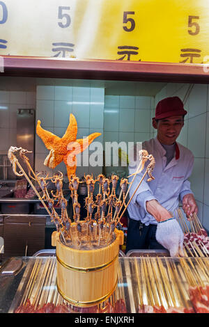 Gli scorpioni, cavallucci marini, stella di mare e altre prelibatezze su spiedini per vendita a Wangfujing Street, il mercato notturno, Pechino, Cina e Asia Foto Stock