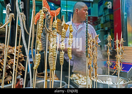 Gli scorpioni, cavallucci marini, stella di mare e altre prelibatezze su spiedini per vendita a Wangfujing Street, il mercato notturno, Pechino, Cina e Asia Foto Stock