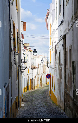Vista lungo la medievale via acciottolata della Rua do Moeda in centro storico di Evora, UNESCO, Alentejo, Portogallo Foto Stock