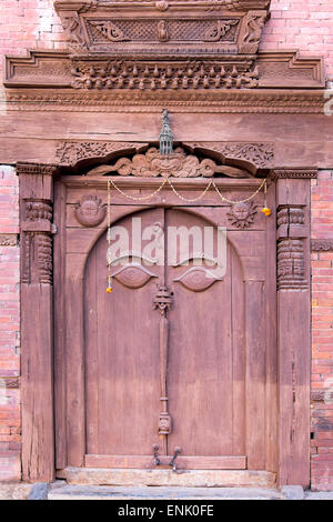 Orate porta di legno in Hanuman Dhoka Royal Palace complesso, Kathmandu, Nepal, Asia Foto Stock