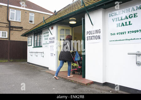 Ickenham, Greater London, Regno Unito. Il 7 maggio, 2015. Un membro del pubblico, immettendo un seggio presso la Village Hall di Ickenham, Greater London, Regno Unito, giovedì 7 maggio 2015. Sondaggi suggeriscono le elezioni generali risultato potrebbe finire in un'altra coalizione. Credito: Timothy Budd/Alamy Live News Foto Stock