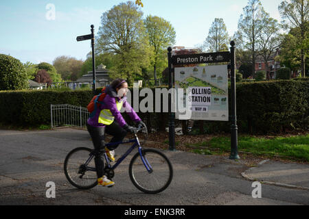 La donna corse in bicicletta lungo un sentiero attraverso Preston Park in Brighton, East Sussex, Inghilterra. Foto Stock