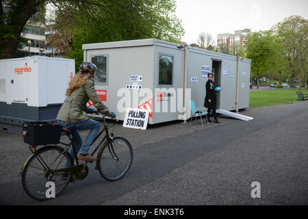 Un ciclista passa un edificio portabile Portakabin che è stato istituito come un seggio per le elezioni generali del 2015 a Preston Park, Brighton, East Sussex, Inghilterra. Foto Stock