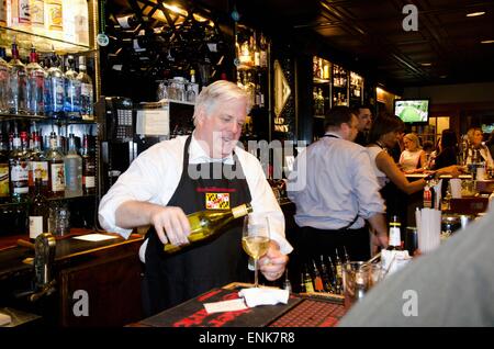 Governatore del Maryland Larry Hogan passi dietro il bar come ospite il barista a Harry Browns Aprile 9, 2015 in Annapolis, Maryland. Foto Stock