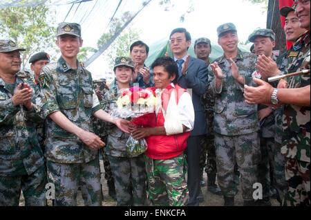 (150507) -- Kathmandu, 7 maggio 2015 (Xinhua) -- i membri di un militare cinese team medico presente un mazzo di fiori per un terremoto feriti vittima dopo il suo trattamento con successo al militare cinese medical camp a Singha Durbar esercito Barrack in Kathmandu, Nepal, 7 maggio 2015. Durante una visita del militare cinese medical camp in Kathmandu con l'Ambasciatore cinese in Nepal Wu Chuntai giovedì, Nepalese il capo del personale dell'esercito Gaurav SJB Rana apprezzato l'efficace e flessibile di assistenza del team cinese che ha lavorato in operazioni di ricerca e salvataggio, così come medico e anti-epidemia FEP