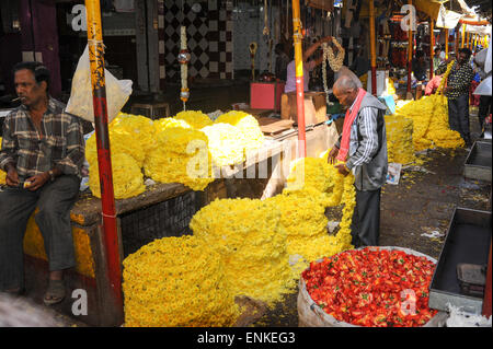 Mysore, India - 24 Gennaio 2015: fornitore indiano che vendono fiori per i clienti nel mercato Devaraja a Mysore in India Foto Stock