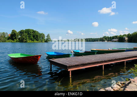 Colorate barche a remi ormeggiate su un molo in legno sul Lago di Galve in Trakai, Lituania, Europa Foto Stock