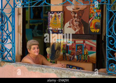 Ritratto di donna seduta in negozio con dipinti a Cuba Havana Foto Stock