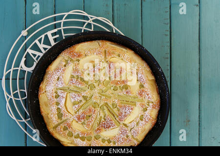 Rabarbaro apple spugna di vaniglia la torta nella teglia da forno e filo di raffreddamento su sfondo turchese con spazio di copia Foto Stock