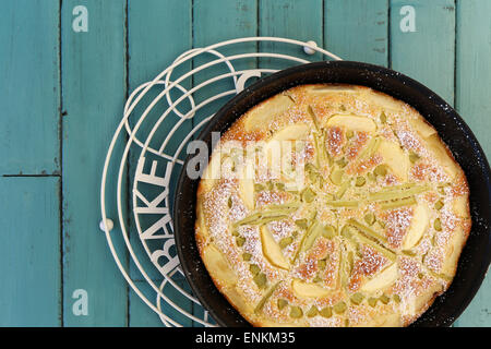 Rabarbaro apple spugna di vaniglia la torta nella teglia da forno e filo di raffreddamento su sfondo turchese con spazio di copia Foto Stock