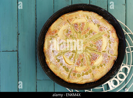 Rabarbaro apple spugna di vaniglia la torta nella teglia da forno e filo di raffreddamento su sfondo turchese con spazio di copia Foto Stock